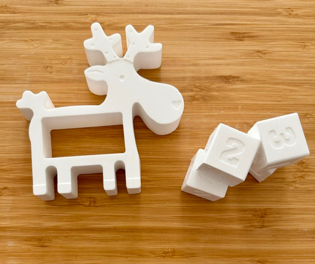 Unpainted reindeer with number blocks plaster kit on wood background