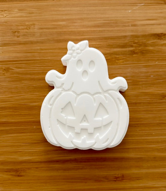 Unpainted Ghost and Pumpkin plaster piece on wood background