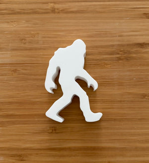 Unpainted Bigfoot Sasquatch plaster figure on wood background