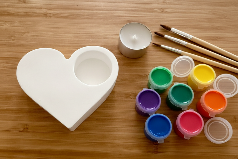 Heart candle holder with paint pots and brushes on wood