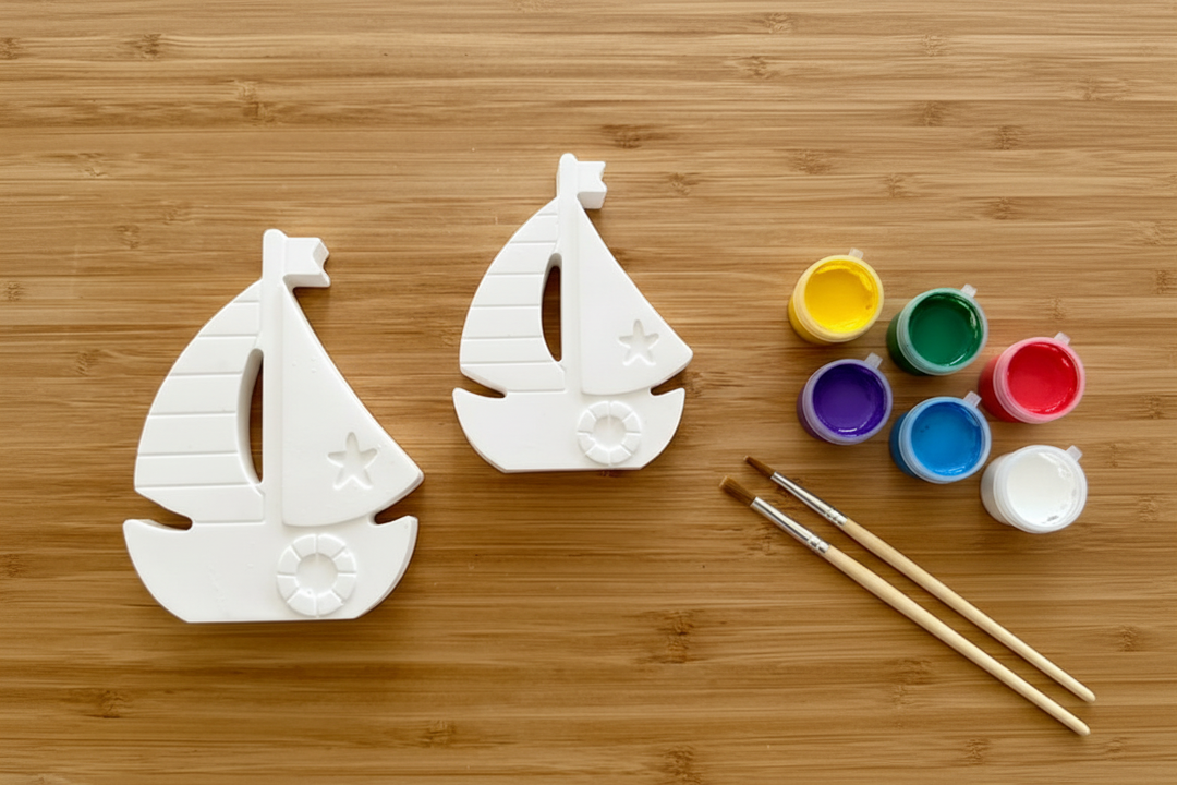 Sailboats with paint pots and brushes on wood