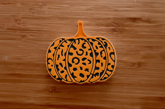 Painted orange leopard pumpkin on wood